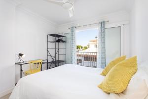 ein Schlafzimmer mit einem weißen Bett und einem großen Fenster in der Unterkunft Coastal Hideaway in Puerto de Santiago