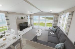a living room with a couch and a table at The Telford Van - Beautiful, luxury static caravan in Aberlour
