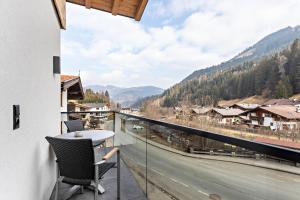 a balcony with a table and a view of a road at Luisalle Top 6 in Auffach