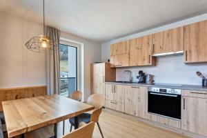 a kitchen with wooden cabinets and a wooden table at Luisalle Top 6 in Auffach