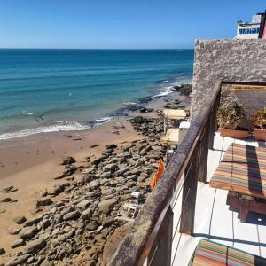 a view of a beach with rocks and the ocean at Balcon sur l'ocean in Taghazout +4 photos