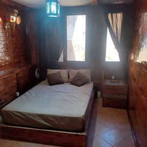 a bedroom with a bed and two windows at Balcon sur l'ocean in Taghazout