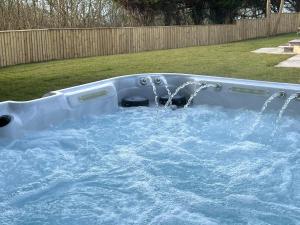 a hot tub with water in a yard at Pembrokeshire Near Beach With A Hot Tub in Pembroke