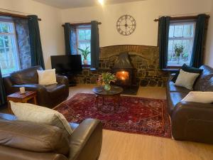 a living room with leather furniture and a fireplace at Pembrokeshire Near Beach With A Hot Tub in Pembroke