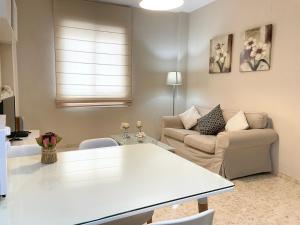 uma sala de estar com uma mesa branca e um sofá em Apartamento Antón Gómez em Lucena