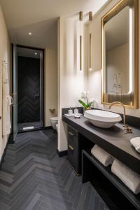 a bathroom with a sink and a toilet and a mirror at Casa Baglioni Milan - The Leading Hotels of the World in Milan