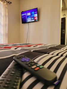 two remote controls sitting on a bed with a tv at Relaxing Place Near the Sea in Ensenada