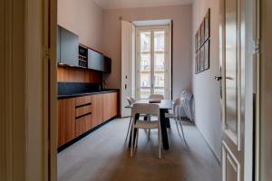 uma cozinha e sala de jantar com mesa e cadeiras em Oddino 3 - 4 Rooms em Turim