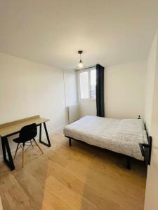 Appartement spacieux et lumineux في سانت بريوك: غرفة نوم بسرير ومكتب وطاولة