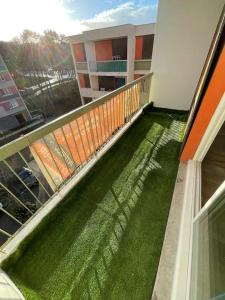Appartement spacieux et lumineux في سانت بريوك: شرفة مع العشب الأخضر على المبنى