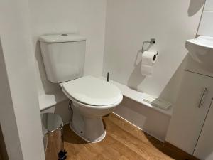 une salle de bain avec des toilettes blanches et un lavabo dans l'établissement Preston Room Let, à Yeovil