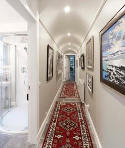 - un couloir avec un tapis rouge au sol dans l'établissement Craggan, à Ballater