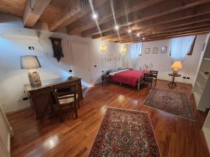a bedroom with a bed and a desk and a table at A CASA DI BARBARA in Monselice