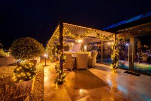 un patio con luces de Navidad, mesa y sillas en Black Barn Spa Swim & Stay, en Great Yarmouth