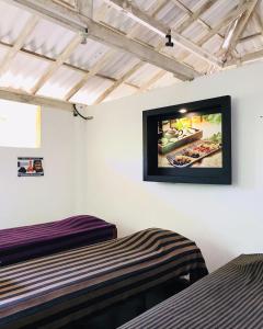 Zimmer mit 2 Betten und einem TV an der Wand in der Unterkunft Mangrove Paradise Resort & spa in Galle