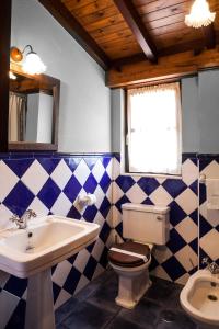 a bathroom with a sink and a toilet and a mirror at Hotel Restaurante Cabo Vidío in Oviñana +65 photos