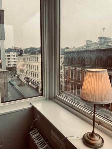una lampada seduta su una scrivania di fronte a una finestra di Le Mat B&B Göteborg City a Göteborg
