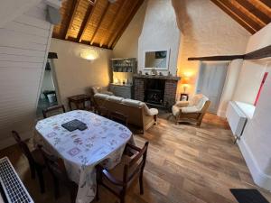 a living room with a table and a fireplace at Carraun Cottage in Manorhamilton