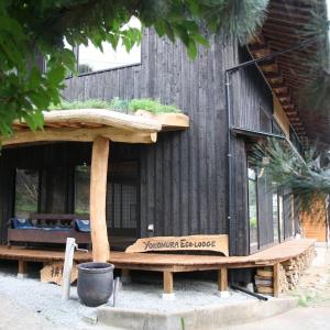 a house with a bench in front of it at Yokomura Eco-Lodge in Uenohara