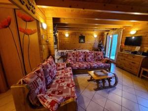 a living room with couches and a table in a room at Chalet Les Ecureuils in Saint-Nabord