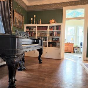 una sala de estar con un piano y un estante de libros en South Court Inn en Luray