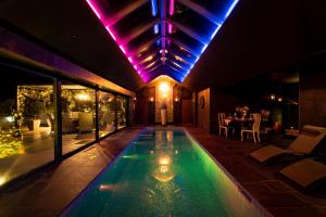 a swimming pool in the middle of a house at night at Black Barn Filby in Great Yarmouth