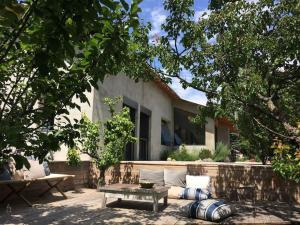 un patio con sofá y mesa frente a una casa en MAISON CALME ET LUMINEUSE OUVERTE SUR LA NATURE, en Truinas