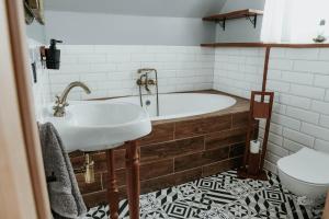 a bathroom with a tub and a sink and a toilet at Zaczarowana Furmanka in Antolka +16 photos