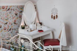 a white dressing table with a mirror and a chair at Zaczarowana Furmanka in Antolka