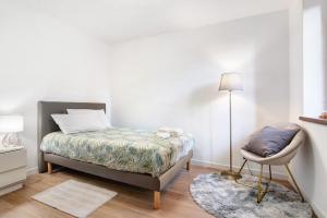 ein Schlafzimmer mit einem Bett, einer Lampe und einem Stuhl in der Unterkunft Fogazzaro Lake View Apartment in Oria
