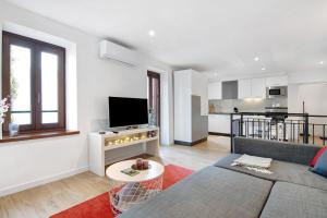 a living room with a couch and a tv at Fogazzaro Lake View Apartment in Oria
