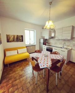 uma cozinha com uma mesa e um sofá amarelo em Ca’ Ruset em Roccaforte Mondovì