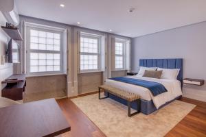 une chambre avec un lit, un bureau et des fenêtres dans l'établissement Porto Almada 180 Apartments, à Porto