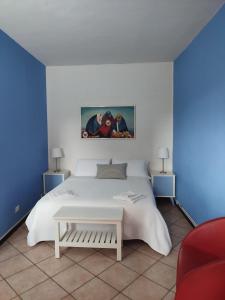 a bedroom with a white bed and blue walls at Antico Affittacamere di Tollegno in Tollegno
