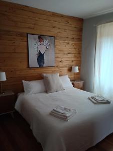 een slaapkamer met een wit bed en een houten muur bij Antico Affittacamere di Tollegno in Tollegno