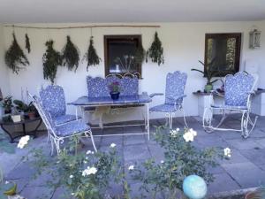 a patio with blue chairs and a table at Sonnenloft Else und Studio Luise in Neubeuern