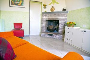 sala de estar con sofá naranja y chimenea en Arabona B&B, en Sulmona