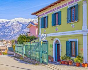 una casa colorida con persianas azules y una valla en Arabona B&B, en Sulmona