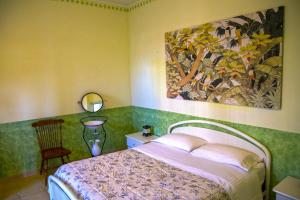 1 dormitorio con 1 cama y una pintura en la pared en Arabona B&B, en Sulmona