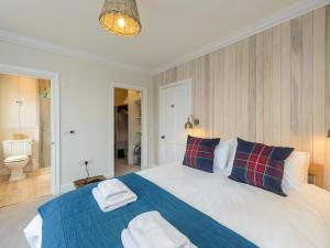 a bedroom with a large bed with a blue blanket at Marine House in Gullane