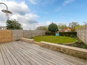 a backyard with a wooden deck and a fence at Marine House in Gullane