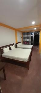 2 duże łóżka w pokoju z: w obiekcie Sinharaja Vini Villa w mieście Deniyaya