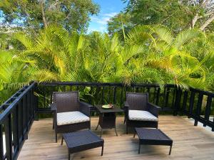 um pátio com cadeiras, uma mesa e palmeiras em Beach Apartment Villas Jubey, Emotion access em Juan Dolio