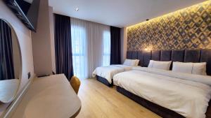 una camera d'albergo con due letti e una grande finestra di StarLight Hotel a Tirana