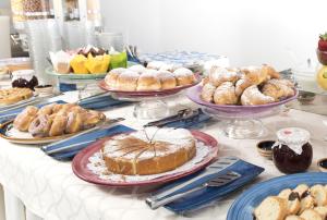 ベッラーリア・イジェア・マリーナにあるHotel Continentalの様々なペストリーやケーキが並ぶテーブル