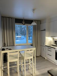 a kitchen with a table and chairs and a window at Wiitakoto in Viitasaari