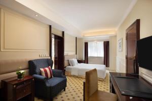 a hotel room with a bed and a chair at Crowne Plaza Hotel & Suites Landmark Shenzhen, an IHG Hotel - Nearby Luohu Border, Indoor heated swimming pool, Receive RMB100 SPA coupon upon check-in in Shenzhen