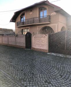 una casa con una valla delante de ella en Катерина en Chynadiyovo