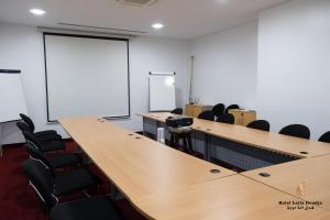 una sala de conferencias con una larga mesa de madera y sillas en Lalla Doudja Hotel en Argel