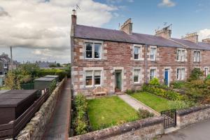 a brick house with a garden in front of it at Hopetoun Cottage in Gullane